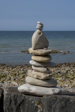 Longues-sur-Mer bataryası. Çakıl taşlı plajda bir cairn manzarası