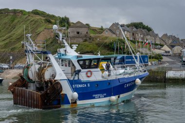 Port-en-Bessin-Huppain, Fransa - 07 24 2023: Limana giren mavi bir balıkçı teknesi