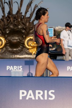 Paris, France - 08 17 2023: Paris 2024 triathlon test event. Women triathletes at the start of the cycling race just after the swimming race on the Alexandre II bridge clipart