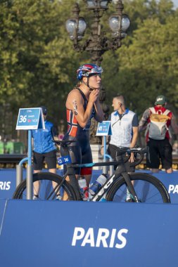 Paris, Fransa - 08 17 2023: Paris 2024 triatlon test etkinliği. Alexandre II köprüsündeki yüzme yarışından hemen sonra bisiklet yarışında kadın triatletler