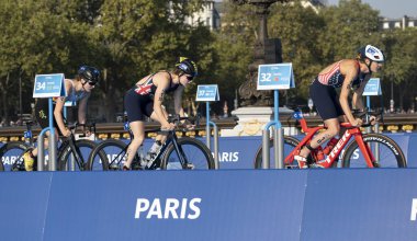 Paris, Fransa - 08 17 2023: Paris 2024 triatlon test etkinliği. Alexandre II köprüsündeki bisiklet yarışında kadın triatletler