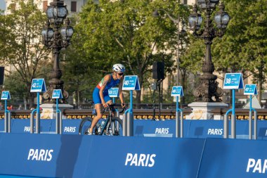 Paris, Fransa - 08 17 2023: Paris 2024 triatlon test etkinliği. Alexandre II köprüsündeki bisiklet yarışında kadın triatletler