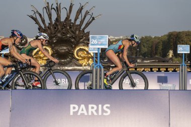 Paris, Fransa - 08 17 2023: Paris 2024 triatlon test etkinliği. Alexandre II köprüsündeki bisiklet yarışında kadın triatletler