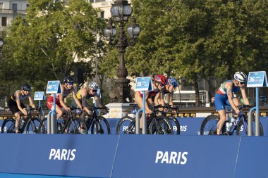 Paris, Fransa - 08 17 2023: Paris 2024 triatlon test etkinliği. Alexandre II köprüsündeki bisiklet yarışında kadın triatletler