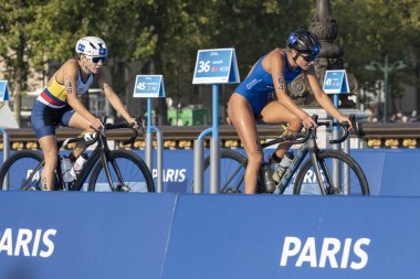 Paris, Fransa - 08 17 2023: Paris 2024 triatlon test etkinliği. Alexandre II köprüsündeki bisiklet yarışında kadın triatletler