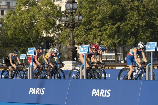 Paris, Fransa - 08 17 2023: Paris 2024 triatlon test etkinliği. Alexandre II köprüsündeki bisiklet yarışında kadın triatletler