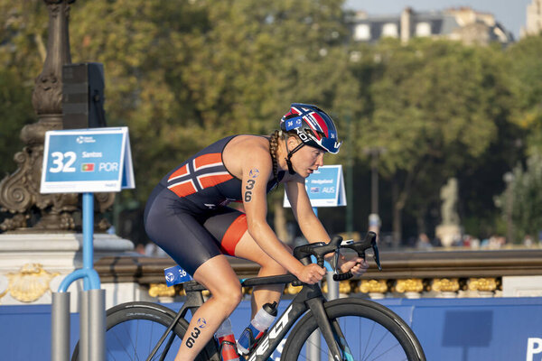 Paris, France - 08 17 2023: Paris 2024 triathlon test event. Women triathletes at the cycling race on the Alexandre II bridge