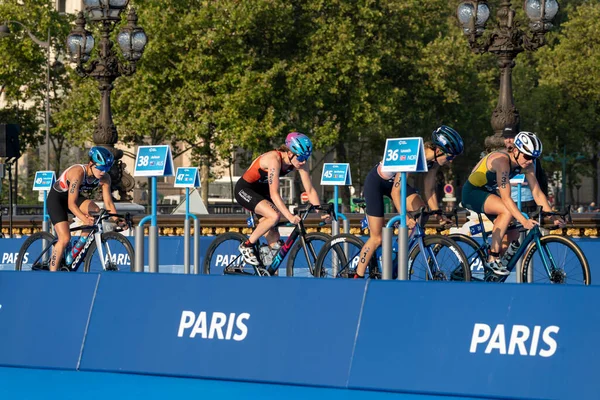 Paris, Fransa - 08 17 2023: Paris 2024 triatlon test etkinliği. Alexandre II köprüsündeki bisiklet yarışında kadın triatletler