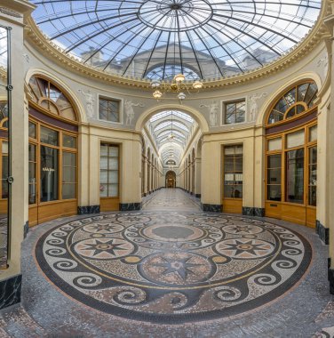 Paris, Fransa - 08 26 2023 Vivienne geçidi. Yerde mozaikler olan geçitten bir sokak manzarası