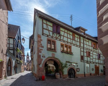 Riquewihr, Fransa - 09 04 2023: şarap rotası. Şehir merkezinde tipik renkli bir cadde manzarası