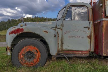 Eski kırmızı ve mavi paslı itfaiye arabası ve orman manzarası
