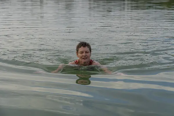 La Raillette, the big lake. A woman is swimming in the water of the lake