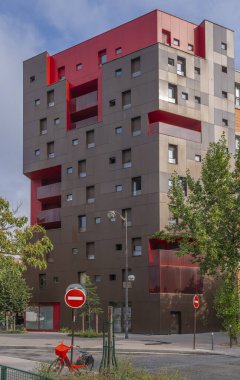 Kırmızı ve kahverengi bir bina, kırmızı bir bisiklet ve kırmızı trafik işaretleri