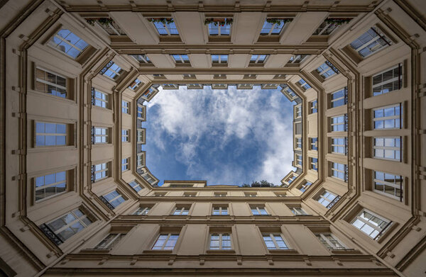 Paris, France - 11 21 2023: View from below of a geometric stone building and blue sky in an inner courtyard