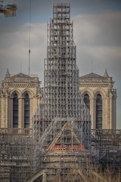 stock image Paris, France - 11 30 2023: Notre Dame de Paris. Panoramic view of the renovation site with scaffolding and the new steeple and Sully Bridge from Austerlitz Bridge