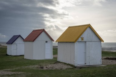 Kum tepelerindeki Gouville 'in renkli banyo yapan ahşap kulübelerinin manzarası.