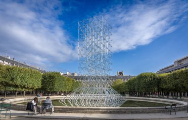 Paris, Fransa - 09: 23 2024: Kraliyet Sarayı bahçesi ve güneş ışığını yansıtan cam bir iskele ile merkez havza manzarası