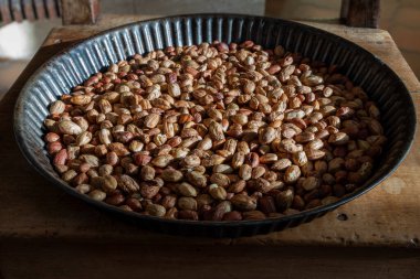 Tahta bir sandalyede turta tabağında soyulmuş fındık.