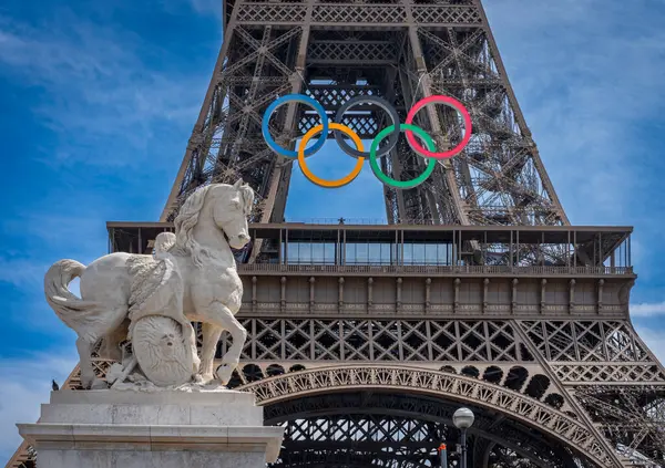 stock image Paris, France - 08 06 2026: View of the Eiffel Tower with the the rings of the Olympic games and a horse's statue from Iena bridge on the Quays of the Seine