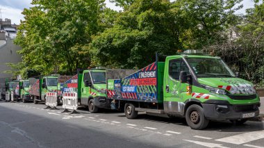 Paris, Fransa - 05: 20 2024: Beş yeşil enkaz kaldırma kamyonunun görüntüsü