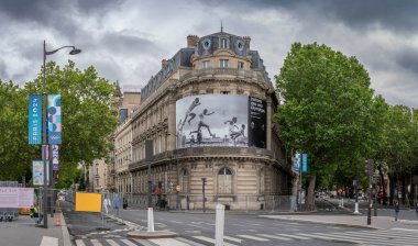 Paris, Fransa - 07 06 2024: Paris Olimpiyat Oyunları 2024. Paris 'teki bir binanın ön cephesini süsleyen 300m' lik bir çan kulesi kovalamacasının dev fotoğrafı