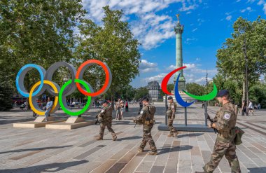 Paris, Fransa - 07: 20 2024: Paris Olimpiyat Oyunları 2024. Temmuz Sütunlu Bastille 'in Yeri, Paralimpik Alevleri, Olimpiyat Halkaları ve silahlı askerler