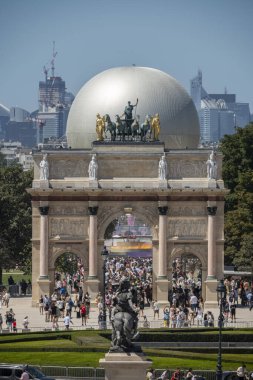 Paris, France - 08 05 2024: Olympic Games Paris 2024. View of the Olympic cauldron behind Arc de Triomphe of Carrousel du Louvre and Napoleon courtyard of Louvre Museum clipart