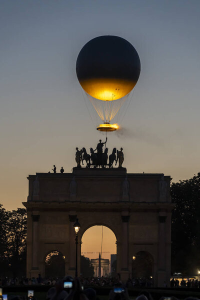 Paris, France - 08 05 2024: Olympic Games Paris 2024. View of the Olympic cauldron behind Arc de Triomphe at Carrousel du Louvre by night