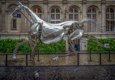 Paris, Fransa - 08: 30 2024: Paris Belediye Binası. Zeus 'un sergisi, Olimpiyat Oyunlarının açılış törenindeki metal at ve yağmurda binicinin zırhı.