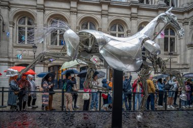 Paris, Fransa - 08: 30 2024: Paris Belediye Binası. Zeus 'un sergisi, Olimpiyat Oyunlarının açılış törenindeki metal at ve yağmurda binicinin zırhı.