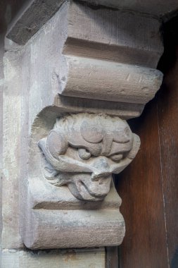 Bernardswiller, France - 09 02 2024: Church of Bernardswiller. View of a devil head sculpture on a door of the church clipart