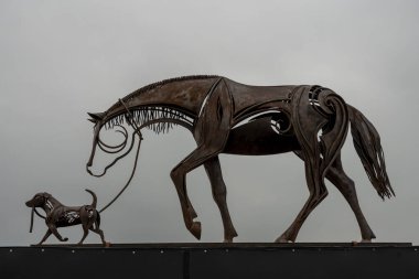 Mers-Les-Bains, France - 09 16 2024:  View of a horse and dog monumental sculpture by Emmanuel Kieffer near the sea clipart