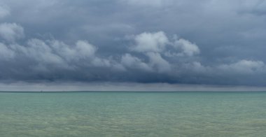 İskelenin panoramik manzarası, deniz ve bulutlu gökyüzü