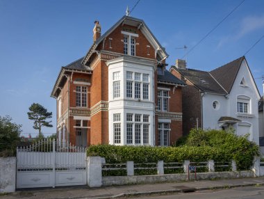 Berck, Fransa - 09: 20 2024: Tipik bir beyaz ve kırmızı villa ve deniz feneri manzarası
