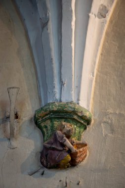 Berck, France - 09 20 2024:  Detail inside Saint John Church of drop of an arch made up of a sculpture of a scene from daily life clipart