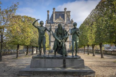 Paris, France - 11 01 2024: Tuileries garden. View of a wide pathway lined with trimmed trees and a Bronze sculpture and Le Louvre facacde behind clipart