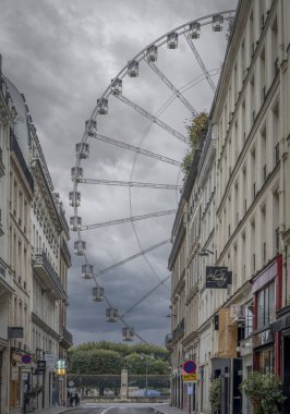 Paris, France - 11 01 2024: View of the ferris wheel merry-go-round of Tuileries garden, Rivoli Street and Haussmannian buildings clipart