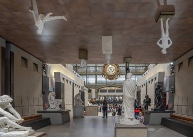 Paris, Fransa - 11 01 2024: Orsay Müzesi. Müzenin ana salonundaki heykellerin manzarası ve cam gölgelik arka plan.