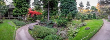 Boulogne-Billancourt, France - 11 12 2024: Albert Kahn's garden. Panoramic view of a wooden villa and colorful trees in a Japanese garden clipart