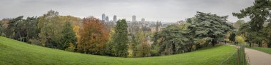 Paris, France - 11 16 2024: Park Buttes Chaumont. Panoramic view of remarkable trees and vegetation with fall colors clipart