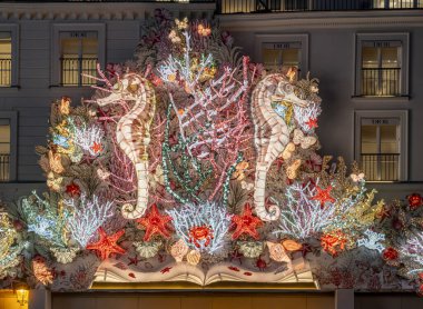 Paris, France - 11 24 2024: View of facade of Christian Dior Paris with christmas decoration at night for Christmas clipart