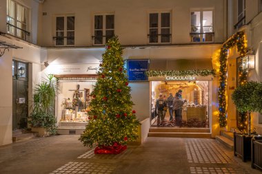 Paris, Fransa - 12: 11: 2024: Geceleri yılbaşı dekorasyonlu bir mağazanın ön cephesi