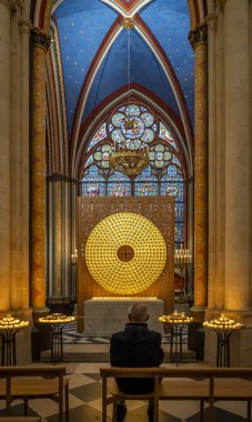 Paris, France - 12 16 2024: Notre Dame de Paris. View a golden circular sculpture and stained glass window inside a chapel of the Cathedral clipart