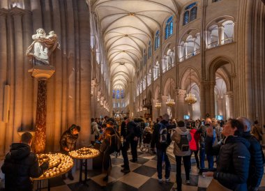 Paris, Fransa - 12: 16 2024 Notre Dame de Paris. Meryem Ana ve İsa heykelinin panoramik görüntüsü, yanan mumlar, kemerler, saflığın vitray penceresi ve katedralin yan koridoru.