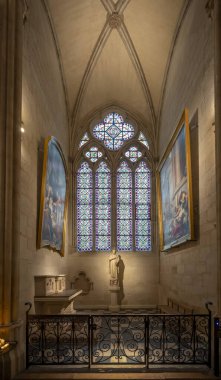 Paris, France - 12 16 2024: Notre Dame de Paris. View a statue, paintings and stained glass window inside a chapel of the Cathedral clipart