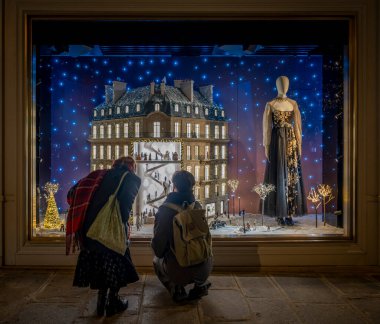 Paris, France - 12 11 2024: View Showcases of Christian Dior Paris with christmas decoration at night for Christmas clipart