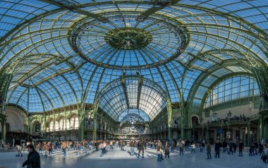 Paris, Fransa - 12 26 26 2024: Le Grand Palais des Glaces: Patenciler, büyük disko topu ve ana navin cam çatısı ile büyük geçici Noel buz pateni pistinin panoramik manzarası