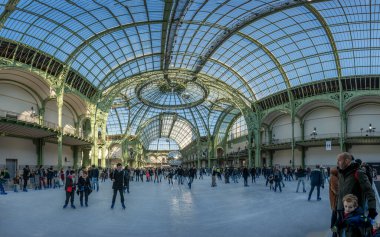 Paris, Fransa - 12 26 26 2024: Le Grand Palais des Glaces: Patenciler, büyük disko topu ve ana navin cam çatısı ile büyük geçici Noel buz pateni pistinin panoramik manzarası