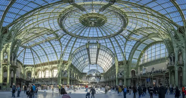 Paris, Fransa - 12 26 26 2024: Le Grand Palais des Glaces: Patenciler, büyük disko topu ve ana navin cam çatısı ile büyük geçici Noel buz pateni pistinin panoramik manzarası
