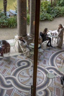 Paris, France - 12 26 2024: Le Petit Palais. View of people sitted in the semicircular peristyle of the courtyard, decorated with Tuscan-style columns and bas-reliefs clipart